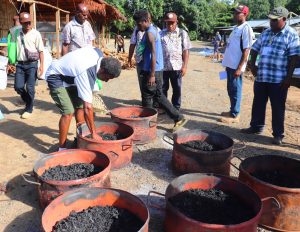 Trainer Byron Yawogi demonstrating how to pre heat charcoal ovens for ‘white copra’ drying.